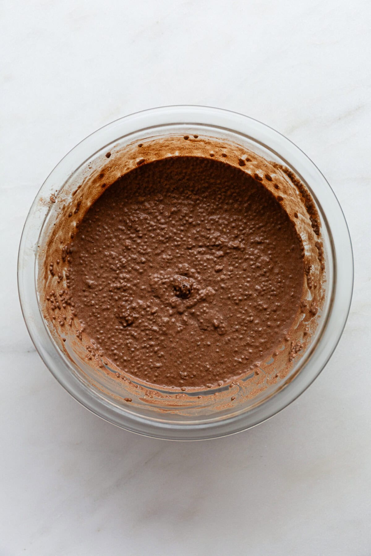 snickers chia pudding in a clear mixing bowl.