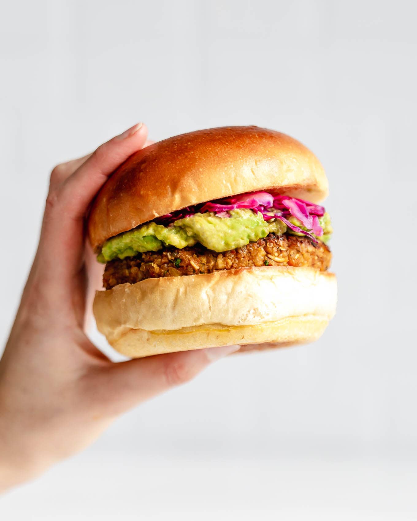 A hand holding a chickpea burger.