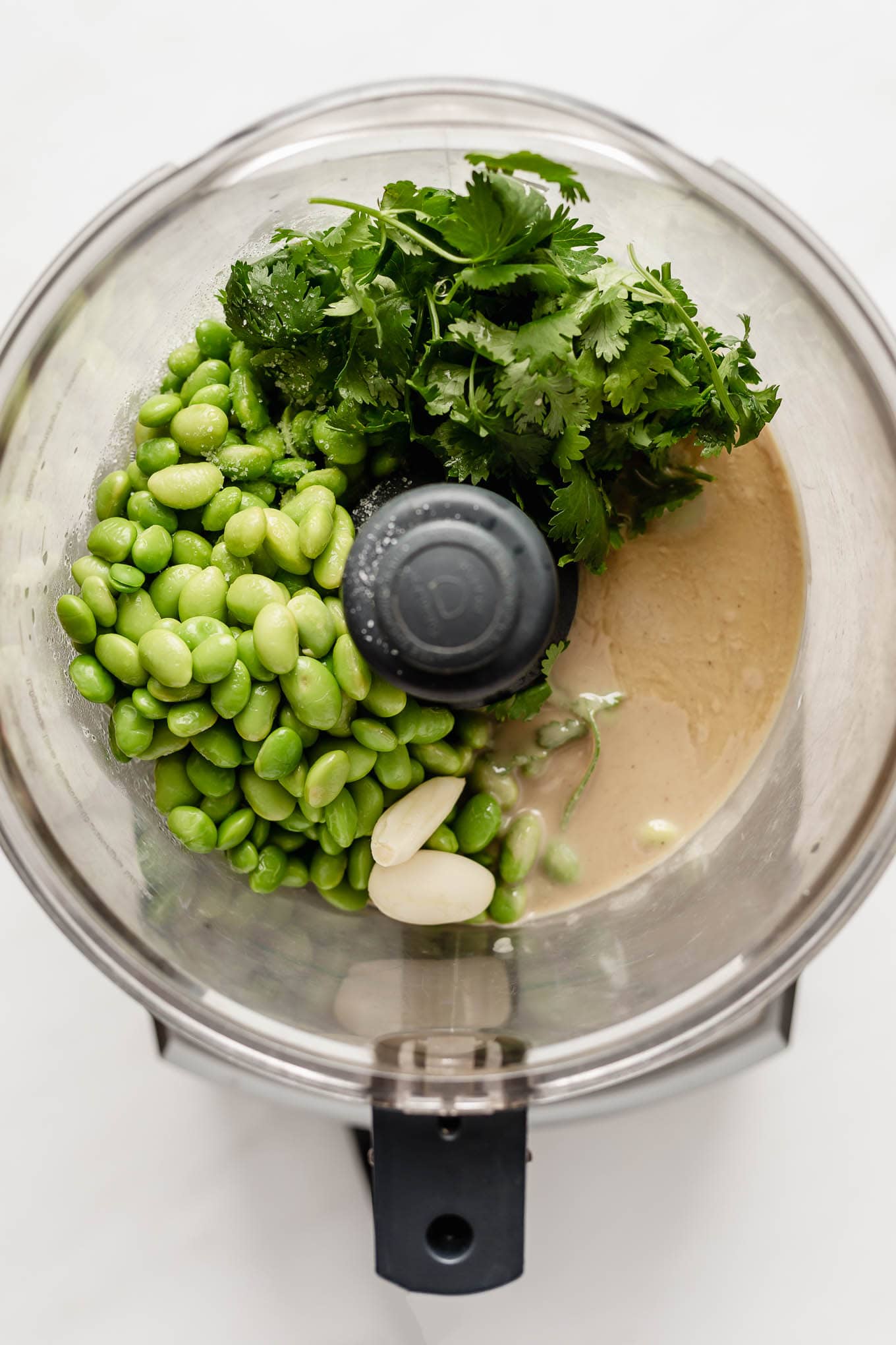 edamame beans, tahini, herbs and garlic in a food processor.