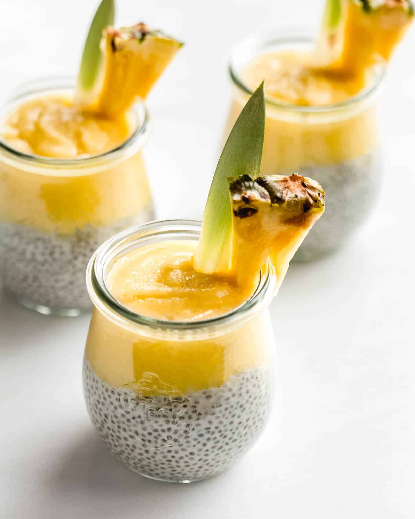pina colada chia pudding cups topped with a pineapple slice.