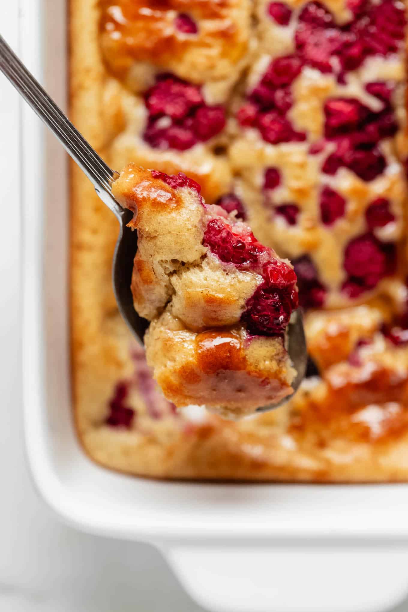 A spoonful of protein pancake bowl with raspberries.