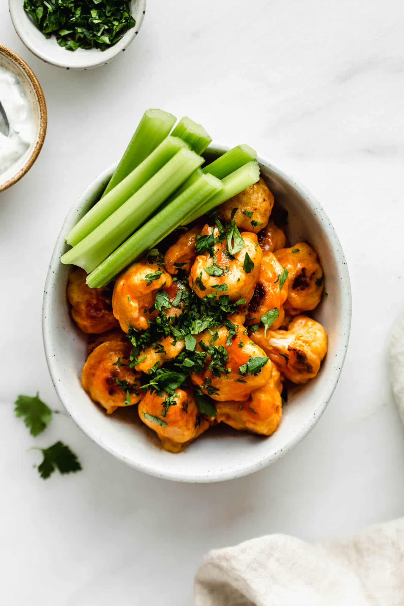 buffalo cauliflower in a bowl with celery.