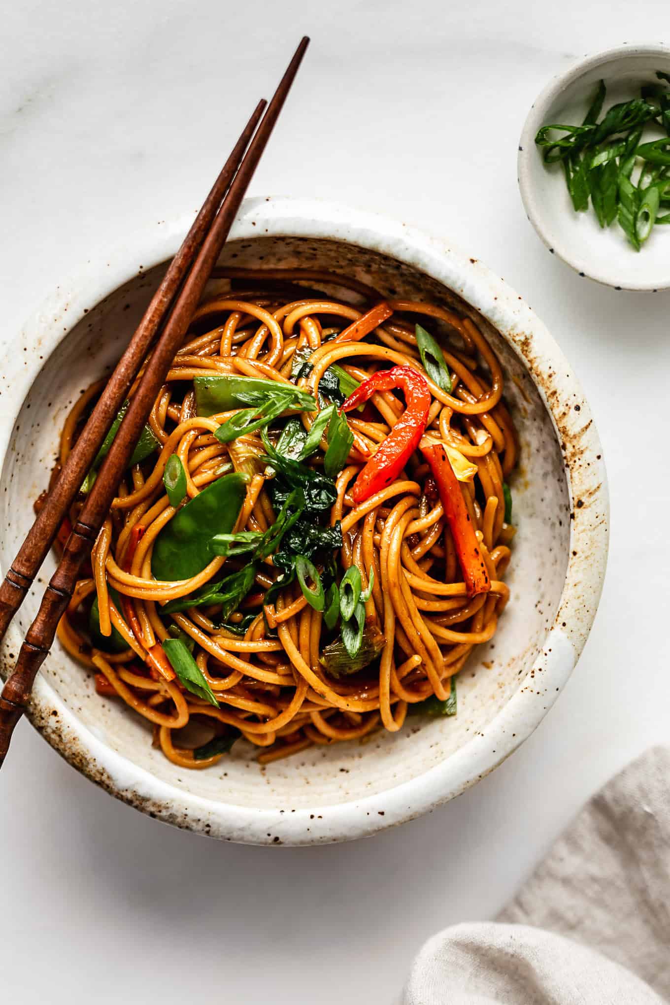 Chinese noodles with vegetables and herbs in a bowl.