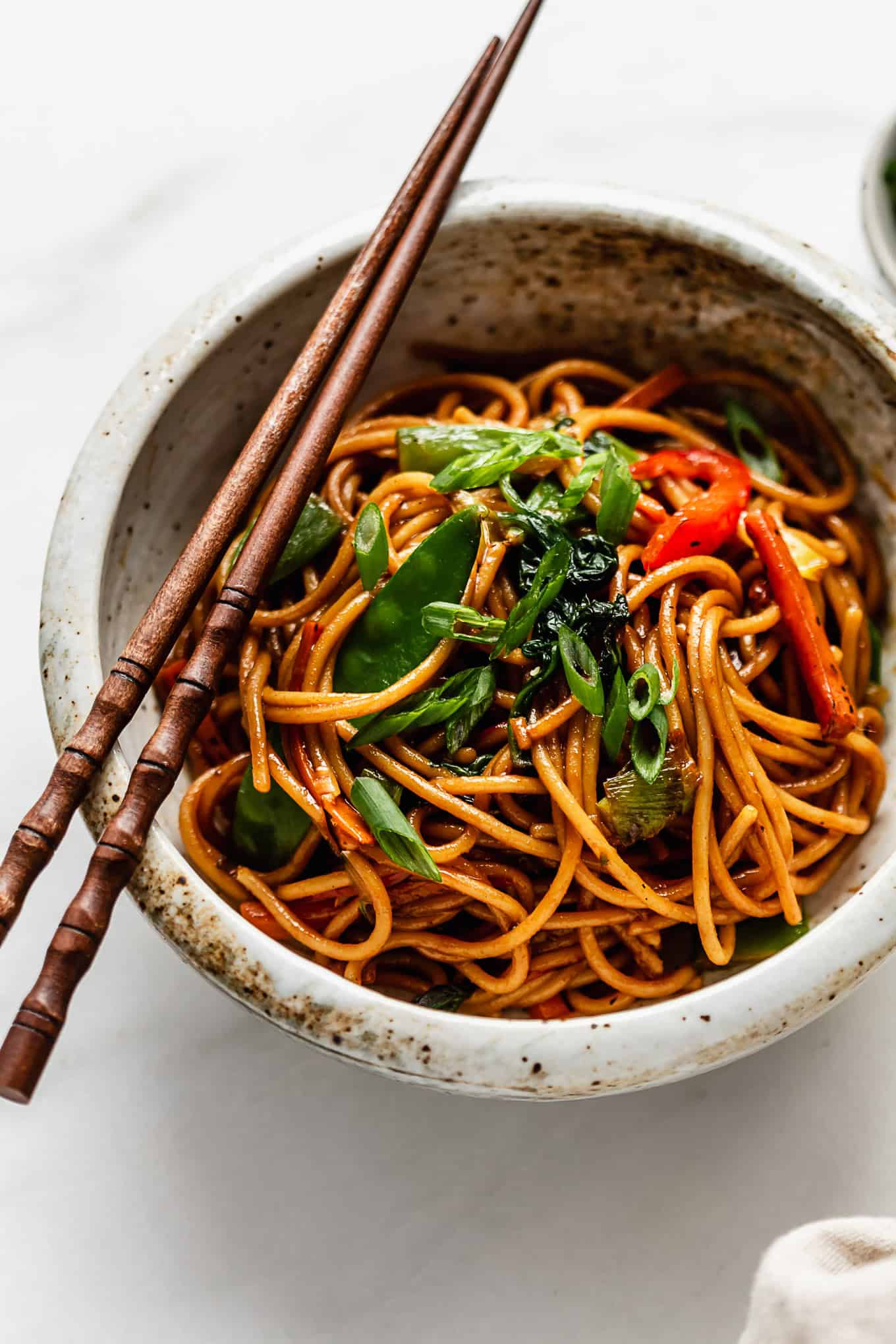 Chinese noodles in a bowl with chopsticks.