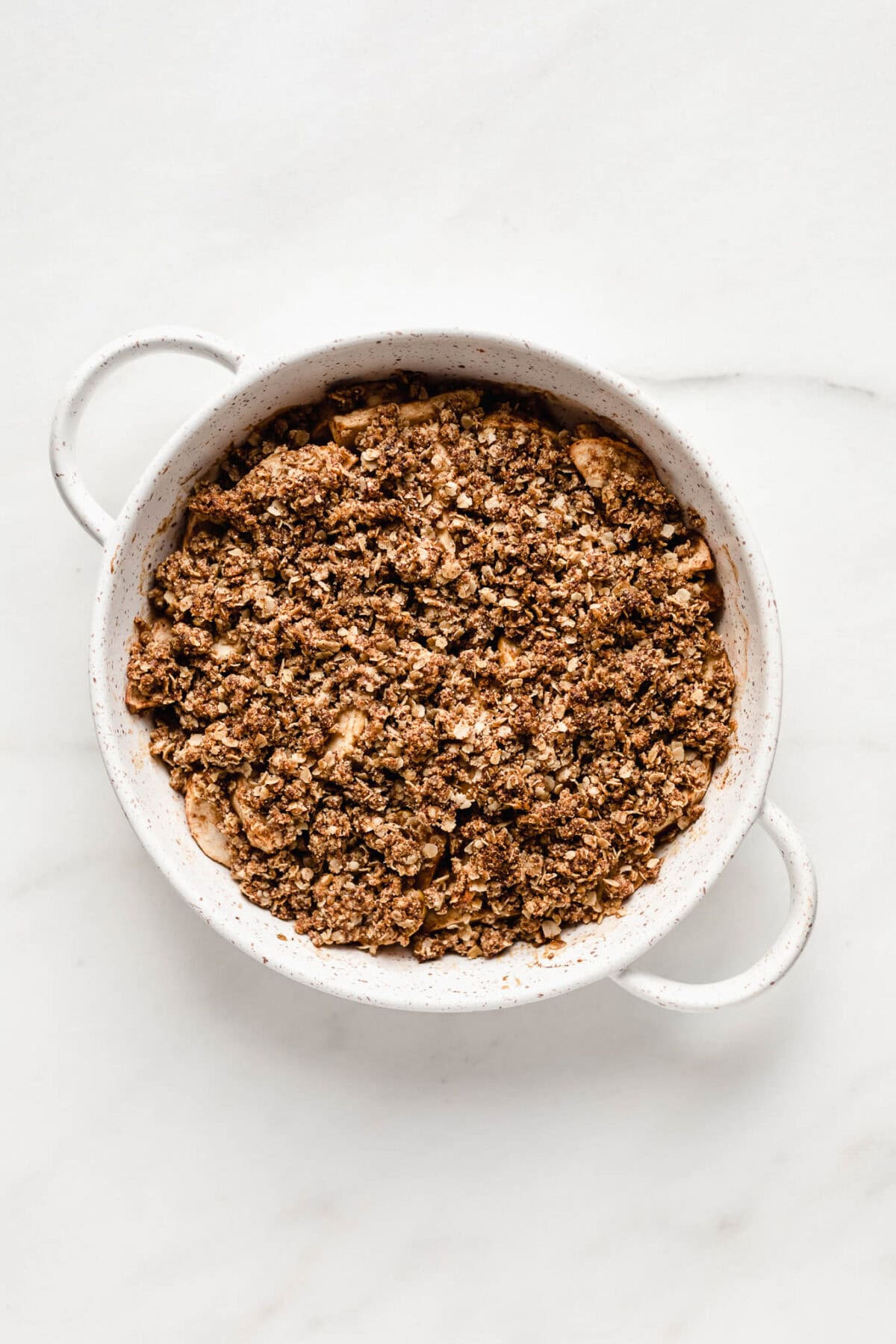 Baked apple crisp in a white round baking crisp.
