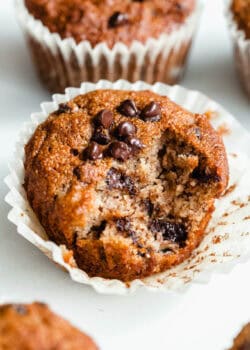 A banana almond flour muffin with a bite taken out of it.