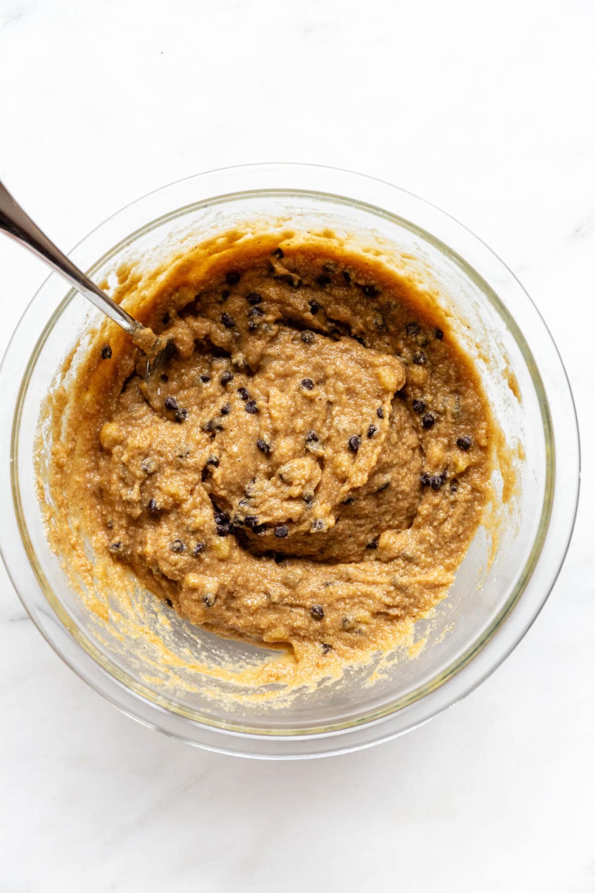 banana almond flour muffin batter in a bowl with chocolate chips.