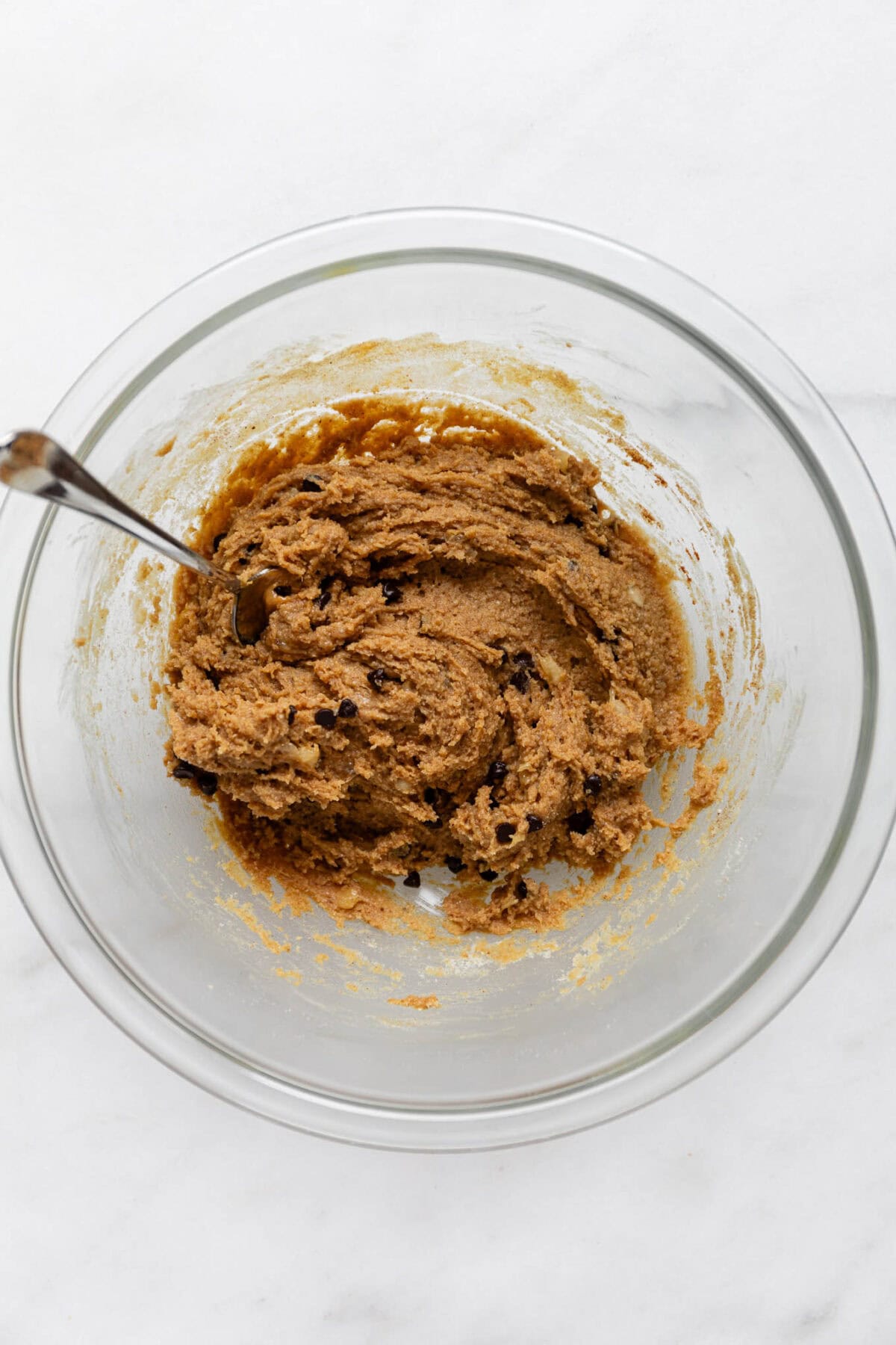 banana protein ball dough in a mixing bowl with a spoon.