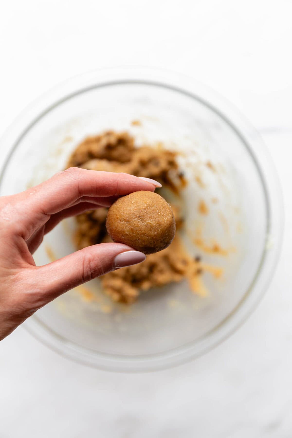 A hand holding a banana protein ball.