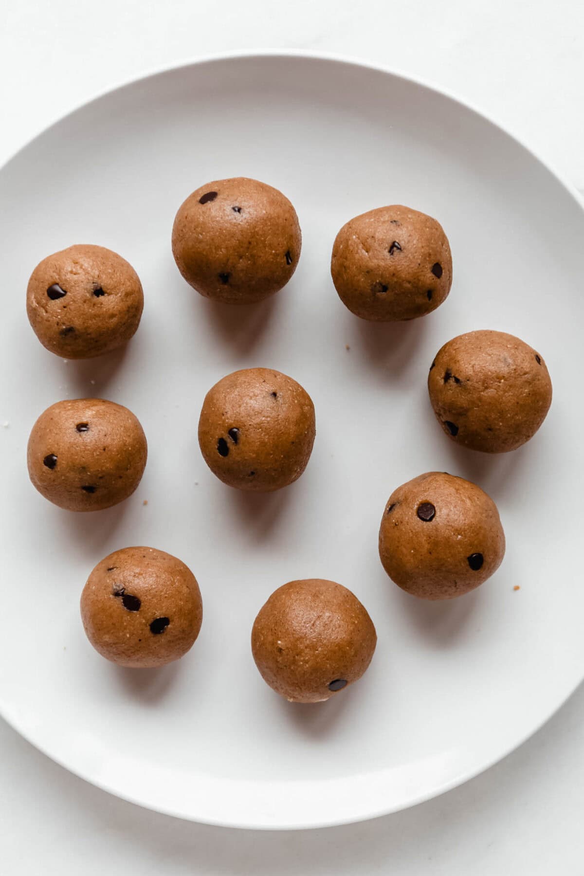 banana protein balls with chocolate chips on a white plate.