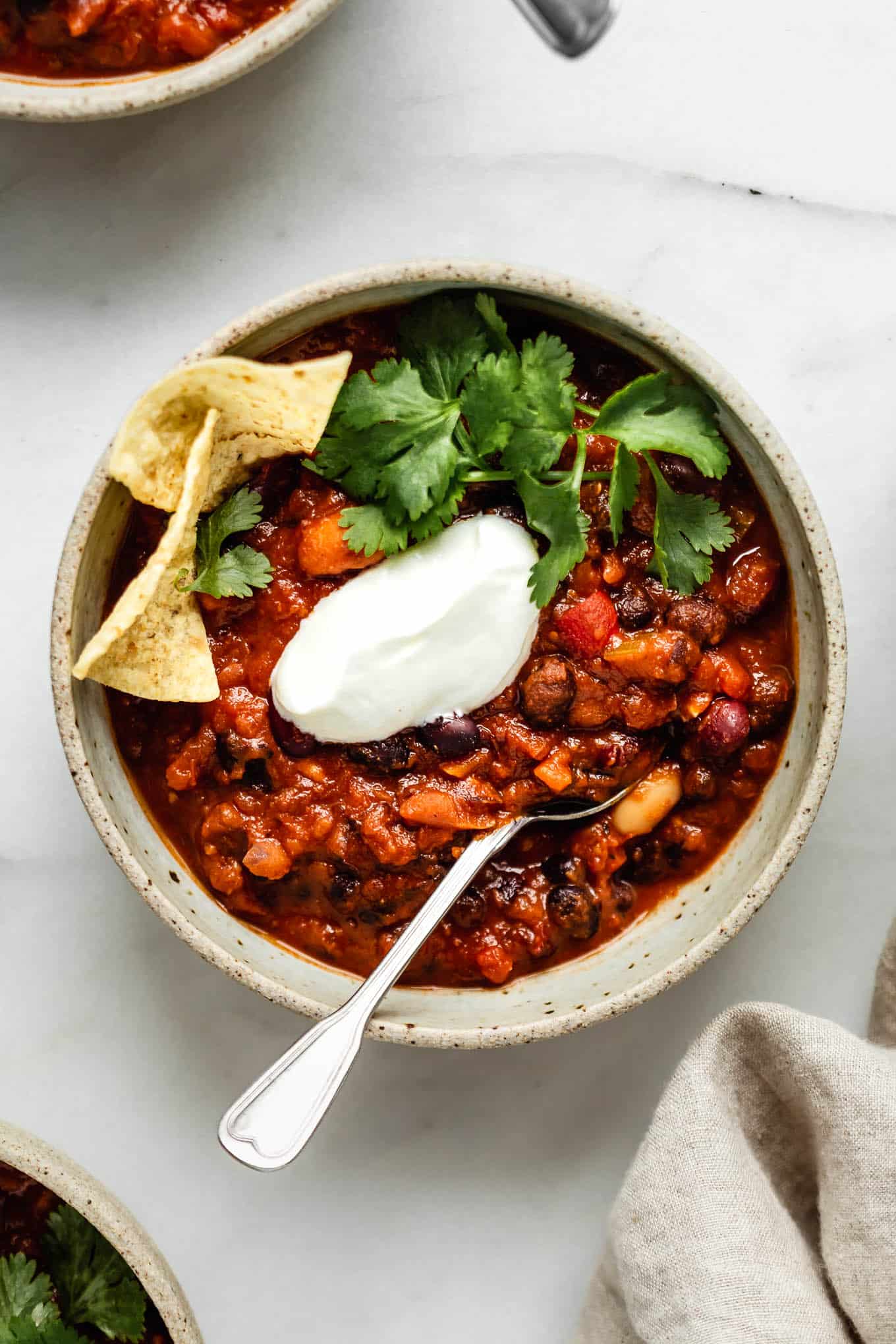 A bowl of instant pot vegan chili with a spoon in it.