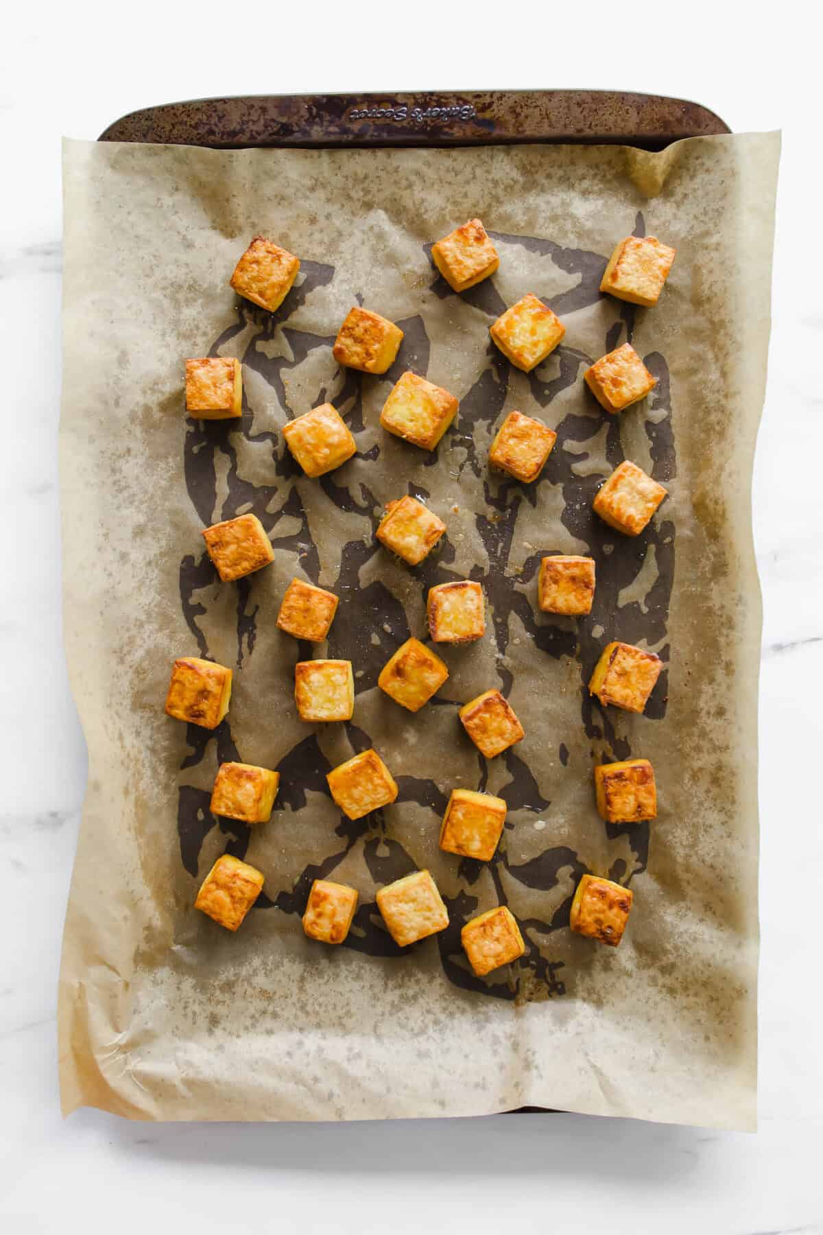 cubes of baked tofu on a baking sheet.