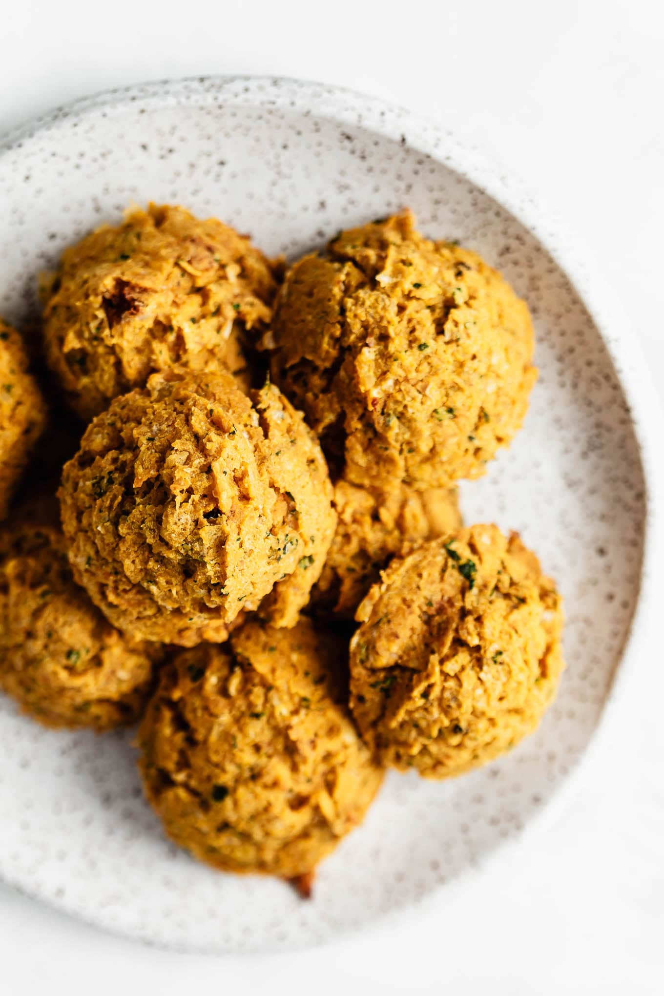 A stack of sweet potato falafel on a speckled white plate.